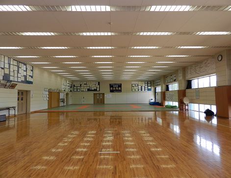 良く磨かれたフローリングの床に続き、畳の床が用意されている体育館一階武道場の写真